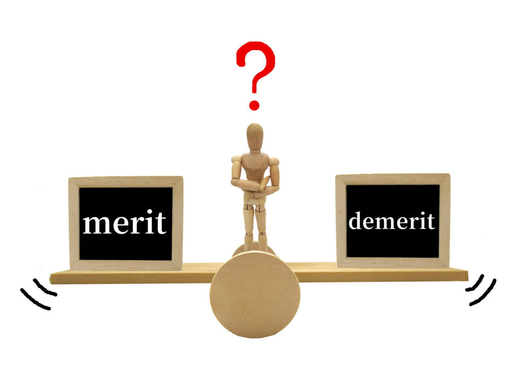 「merit」と「demerit」が乗せられた天秤