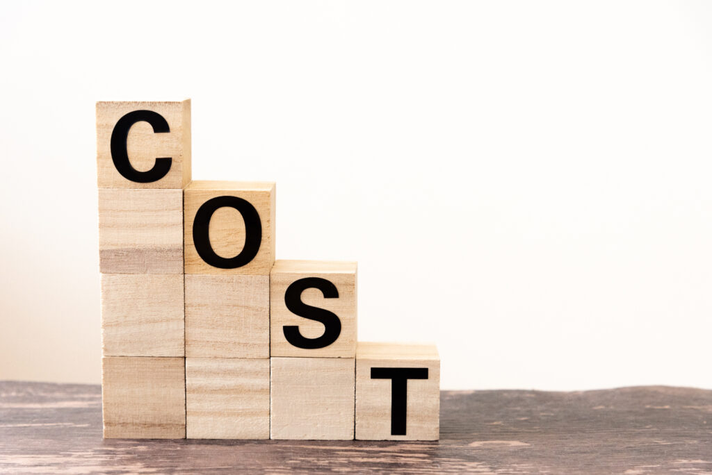 「COST」と書かれた積み木　値段が下がるイメージ